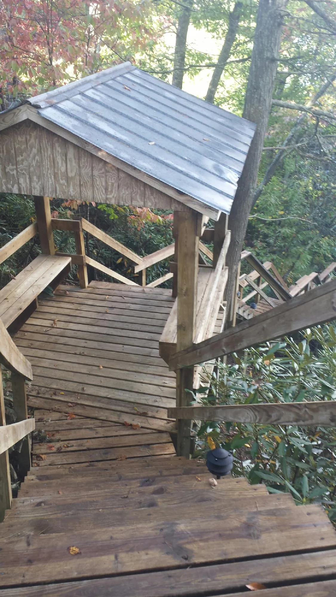 Metal roofed shelter over wooden steps on a wooded walkway — Skylight Repair & Installation work by our crew in State College